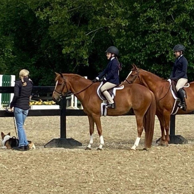 riding coach talks with her students at a horse show