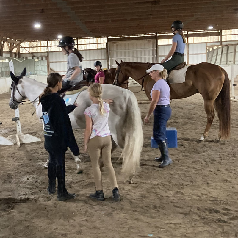 riders in an indoor arena